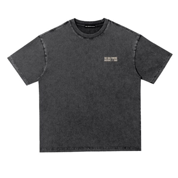 Alternate view of The Transit Tee in black showing the vintage wash and travel-stamp print detail