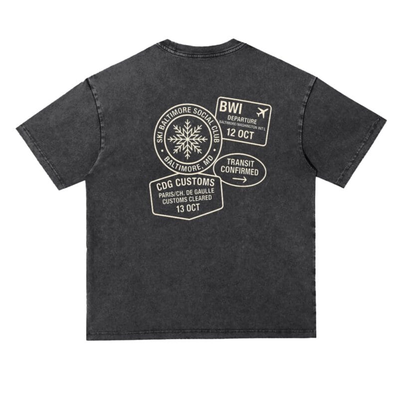 The Transit Tee in black, a vintage-wash cotton T-shirt with a travel-inspired customs stamp design